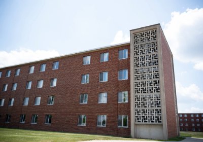 Side view of Emmons Hall showing red brick exterior and a decorative concrete stairwell panel.