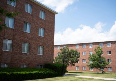 Two red brick residence buildings and a walkway between them, part of Herrig Hall complex.