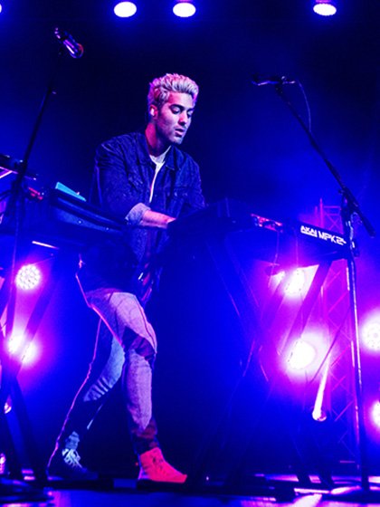Man playing the keyboard during a concert.