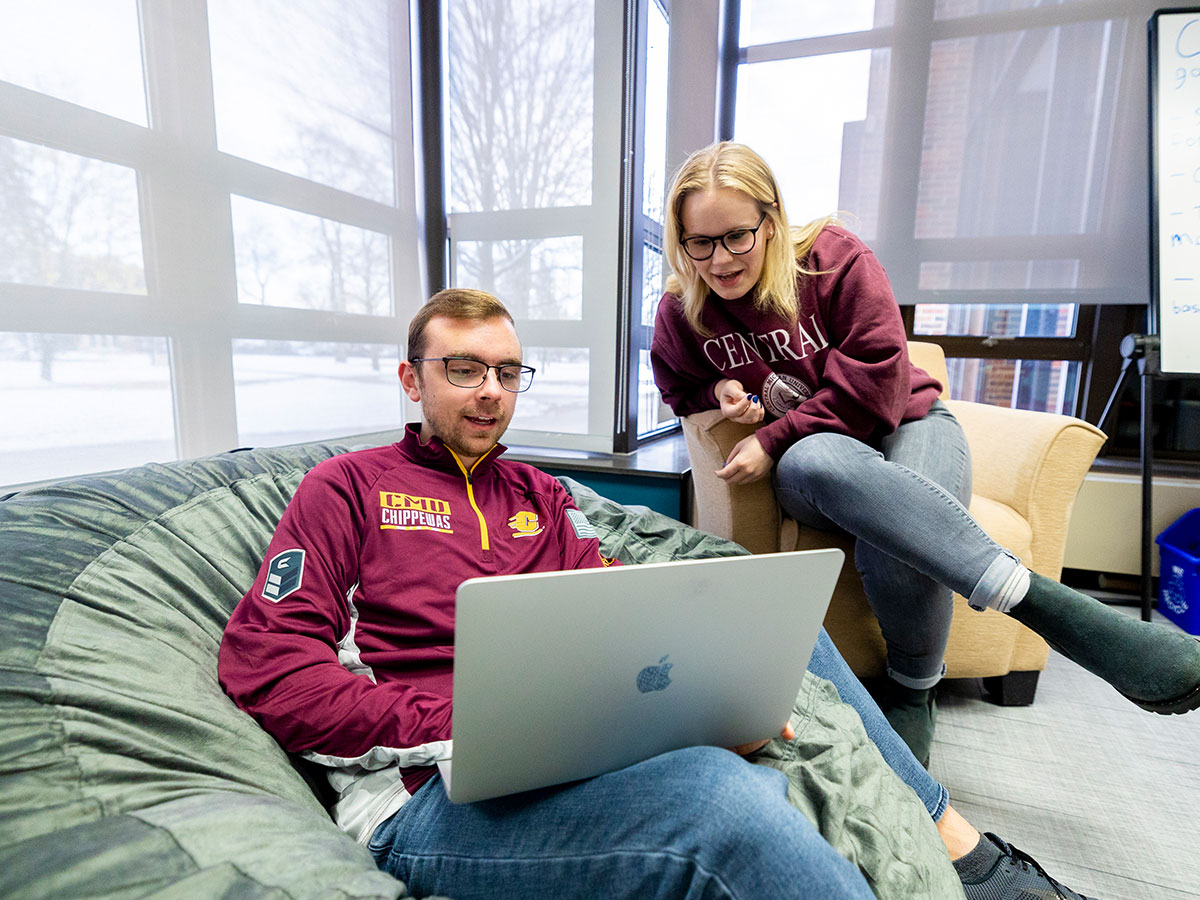 Two students looking at an apple laptop.