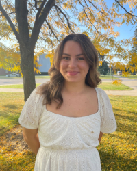 Headshot of Olivia in a white dress