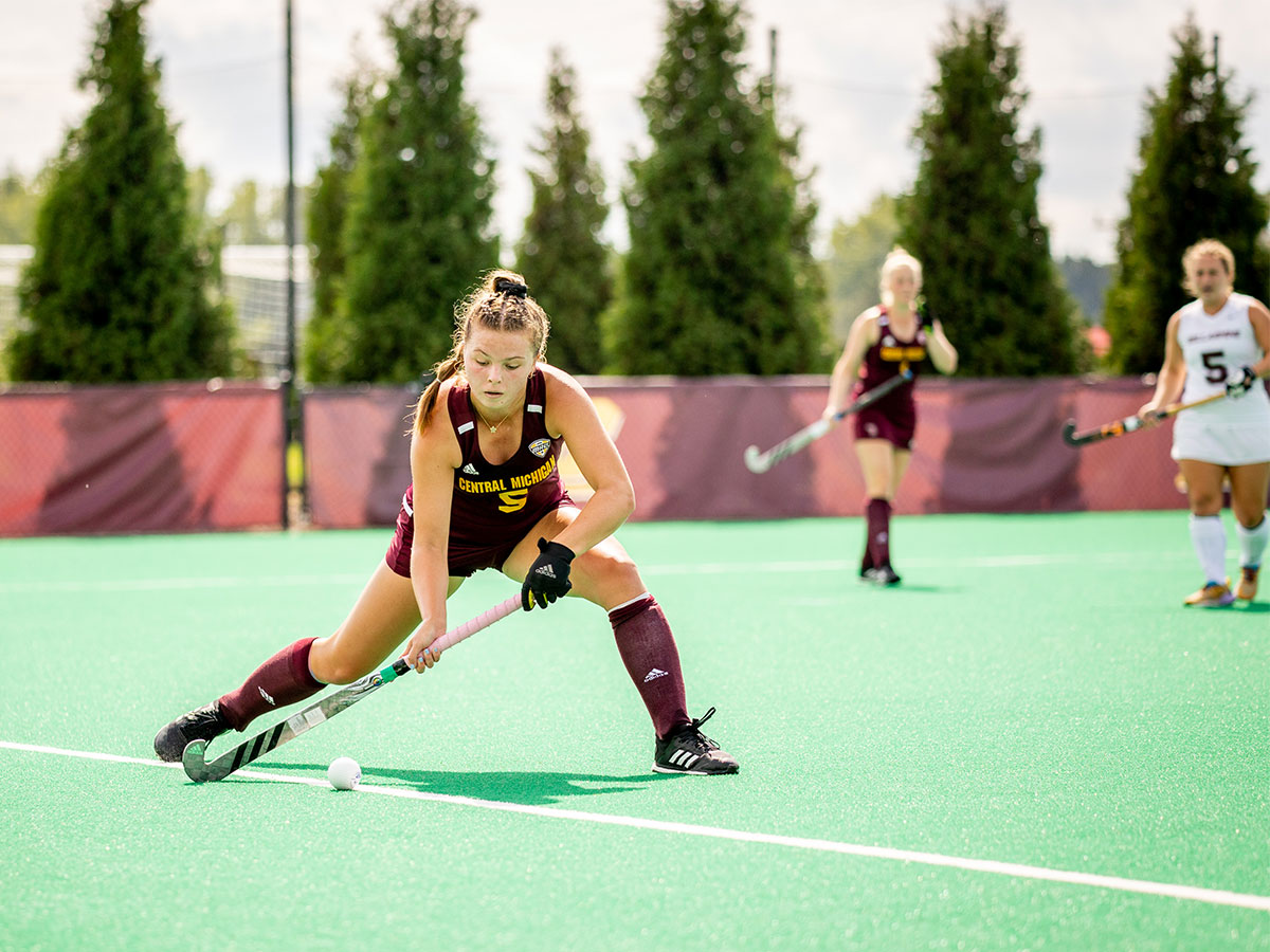 A female CMU student athlete playing field hockey