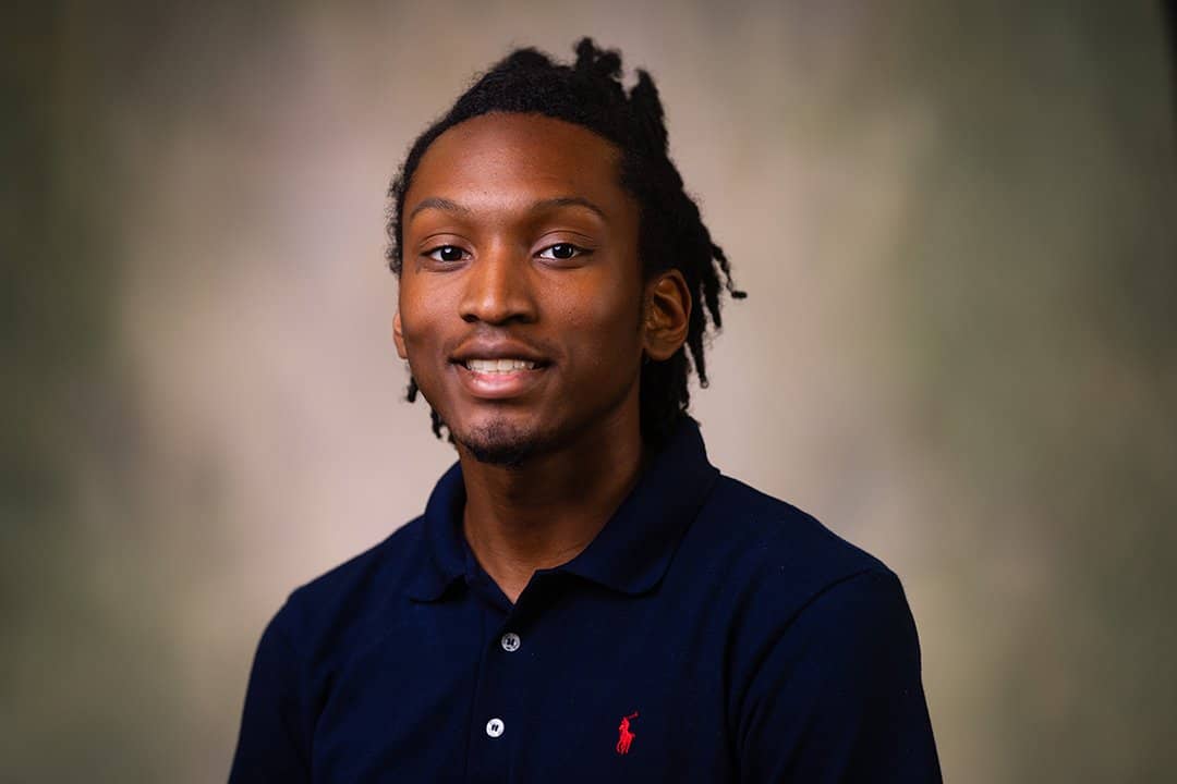 Professional headshot of Galen Raymond wearing a black polo shirt while looking at the camera.
