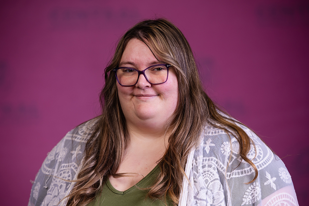 Professional headshot of Amy Ferguson wearing a green shirt with sheer white sweater while looking at the camera.