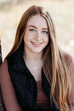 AddieFollowellforWeb A photo of SI Leader, Addie Followell, posing outdoors and leaning on a tree.
