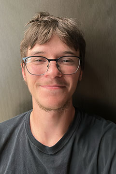 ConnerforWeb A photo of SI Leader, Conner Ripley, smiling in front of a grey backdro