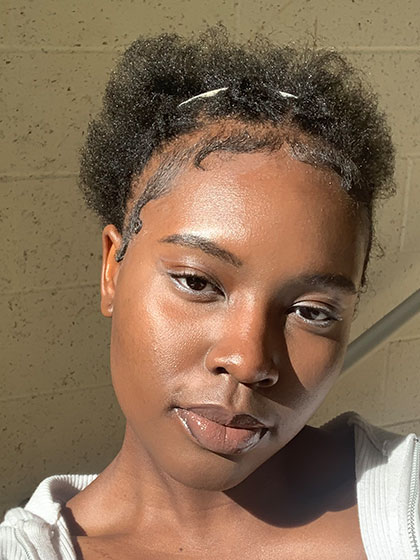 Eneni-for-Web A headshot of SI Leader Eneni Alagoa posing in a white sweater in a stairway