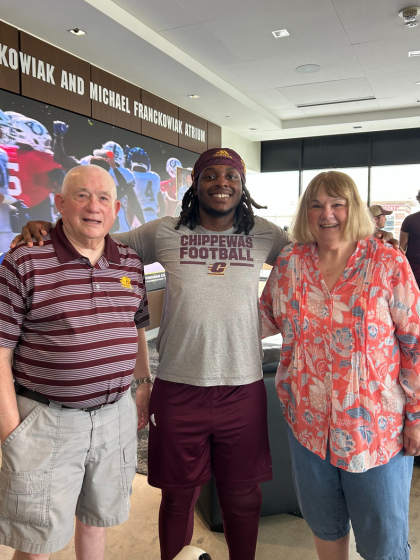A group of three people pose for a photo