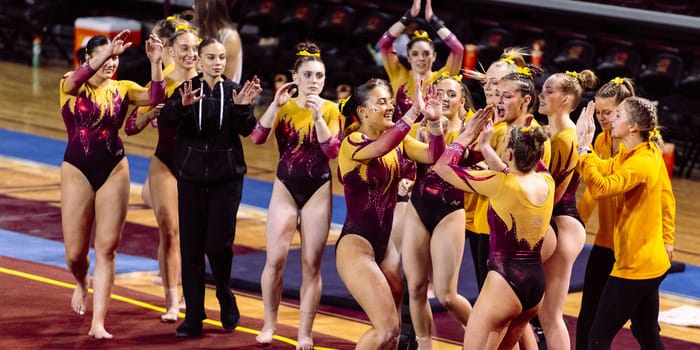 CMU gymnastics team celebrating during a competition.