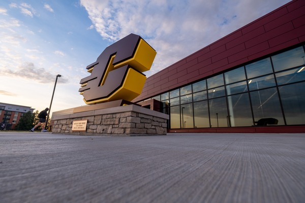 Close-up of the Action C signage in front of the CMU Athletics building entrance.