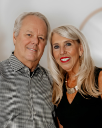 A man and woman wearing black and white smiling together.