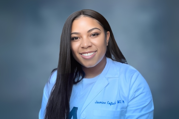 a woman with long hair wearing a white lab coat