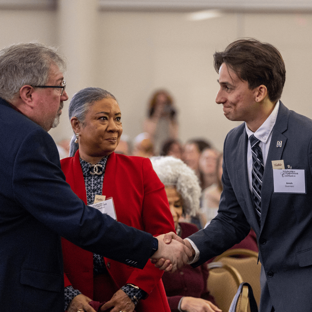 an alum shaking hands with a current student